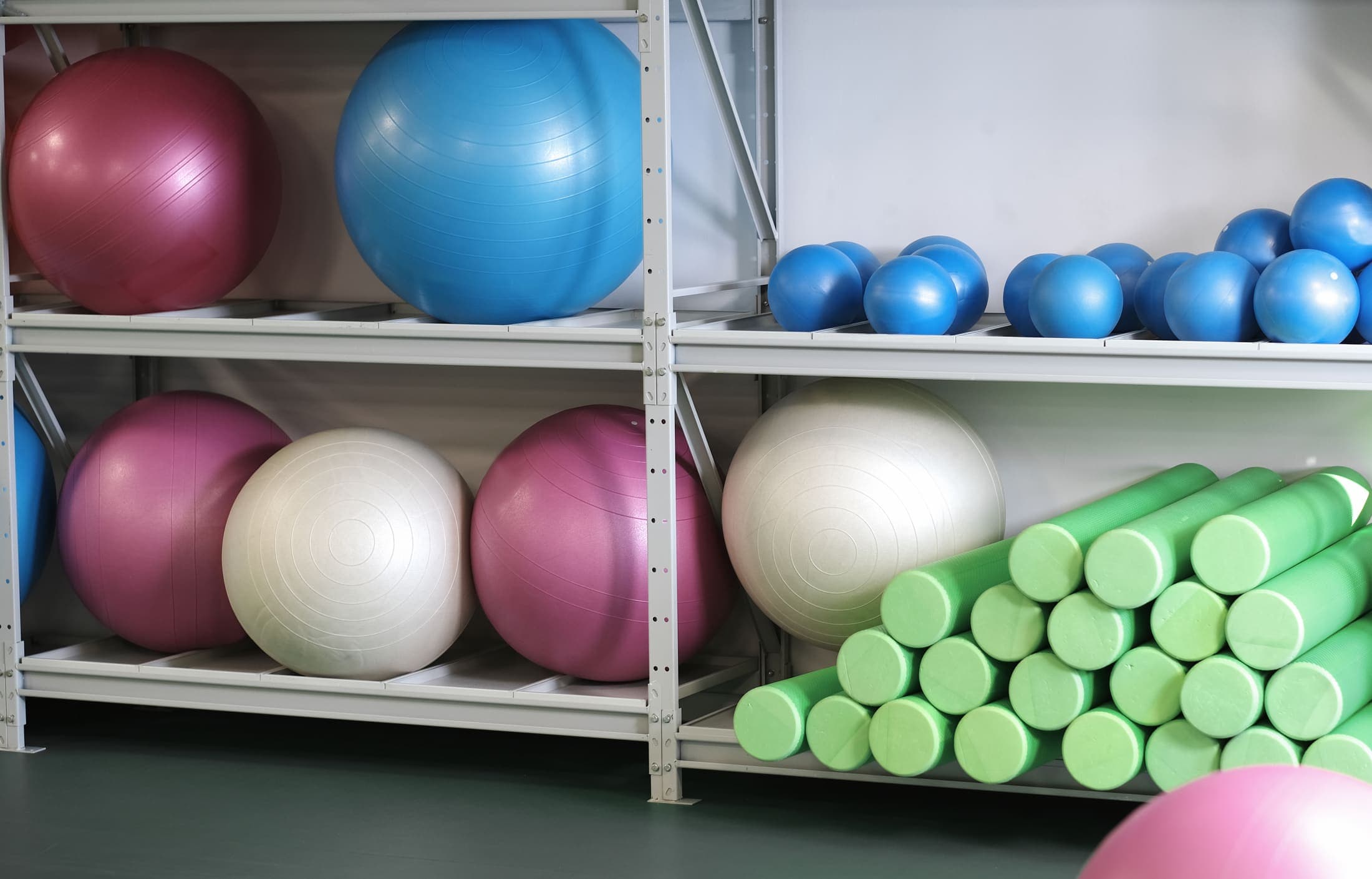 Oefenmateriaal in de praktijk: fitnessballen en foamrollers.